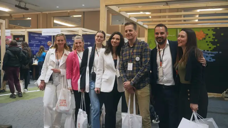 Izlagači ispred štandova s drvenim stropom od lamela